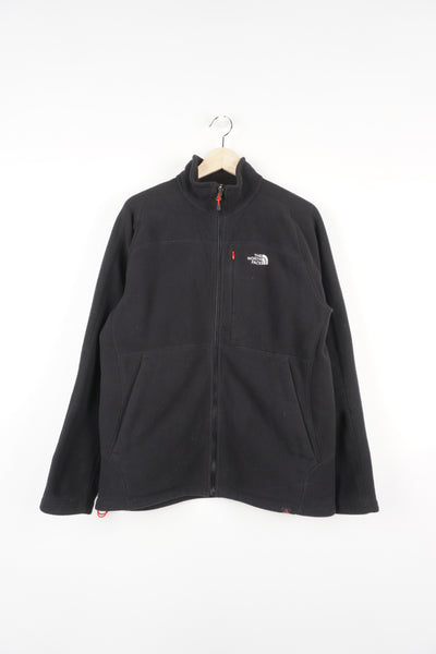 The North Face black zip through fleece, features zip up pockets and embroidered logo on the chest