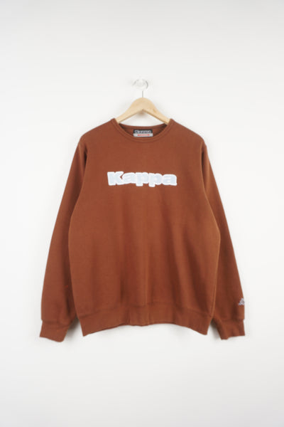 Brown Kappa crewneck sweatshirt with baby blue embroidered spell-out logo on the chest and small logo on the sleeve good condition  Size in Label:  M