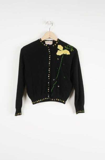 Vintage 1950's black cashmere cardigan. Made in Hong Kong by Bonnie Wong, features detailed floral embroidery and faux pearl buttons to close. The cardigan is a cropped fit with 3/4 length arms.   good condition - missing the top button.   Size in Label:  No Size - would estimate that it would fit a size S/M best