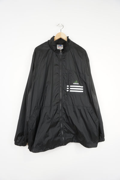 Late 90's all black Adidas zip through windbreaker coat features embroidered logo and three stripe details on the chest pocket
