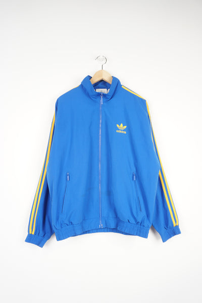 1990s Adidas blue zip through tracksuit top, features yellow three stripe details down the arm, with embroidered logo on the chest