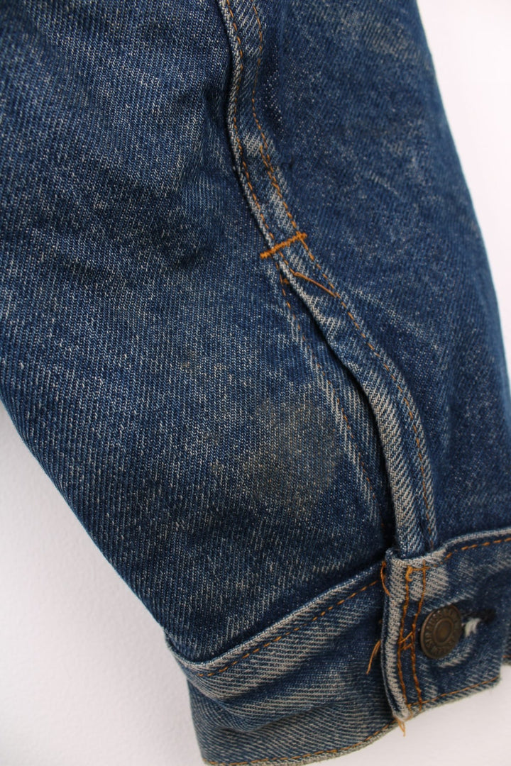 Levi's Denim Jacket in a blue colourway, button up with double chest pockets, has a blanket lining, and the logo embroidered on the front. 