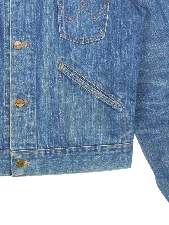 Vintage Wrangler Denim Jacket in a blue colourway. Buttons up and has multiple pockets, and the logo tab embroidered on the front.