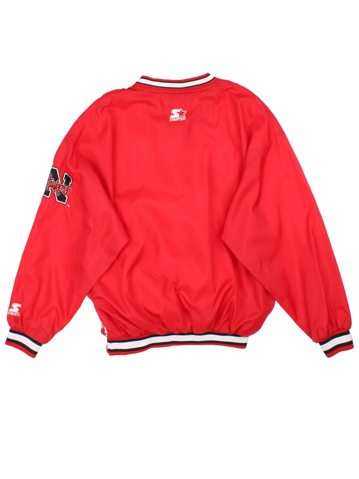 Starter Nebraska Drill Top in the red colourway. Features contrast cuffs/hems, side pockets and logos embroidered on the front/back/sleeve.