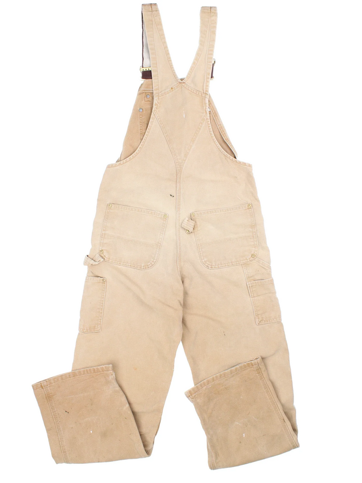 Carhartt Double Knee Dungarees in a tan colourway with multiple pockets and the logo embroidered on the front.