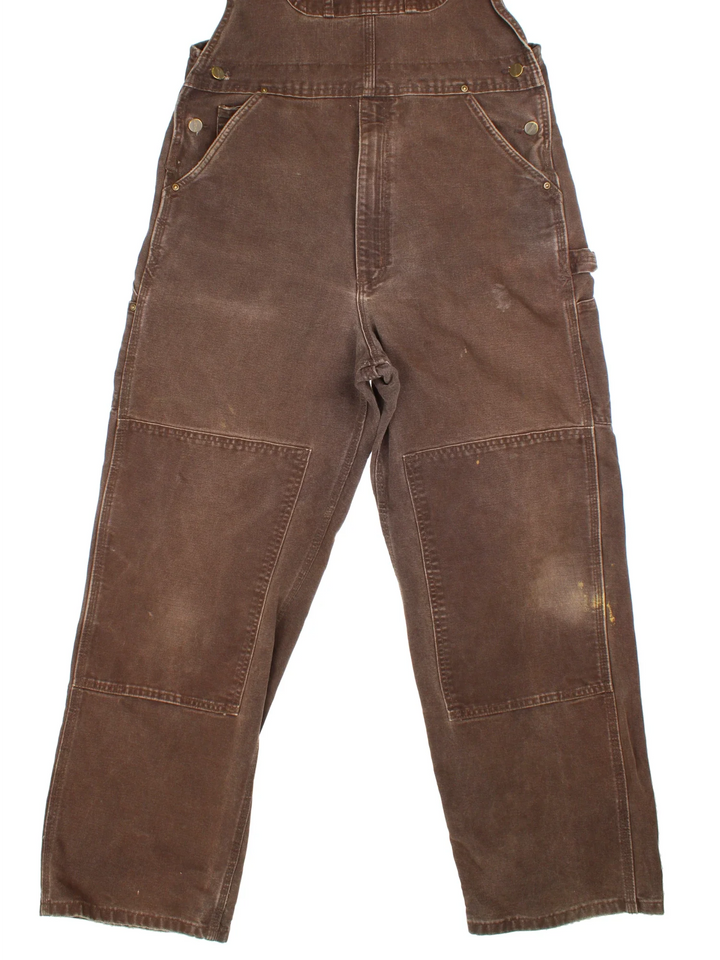 Carhartt Double Knee Dungarees in a brown colourway with multiple pockets and the logo embroidered on the front.