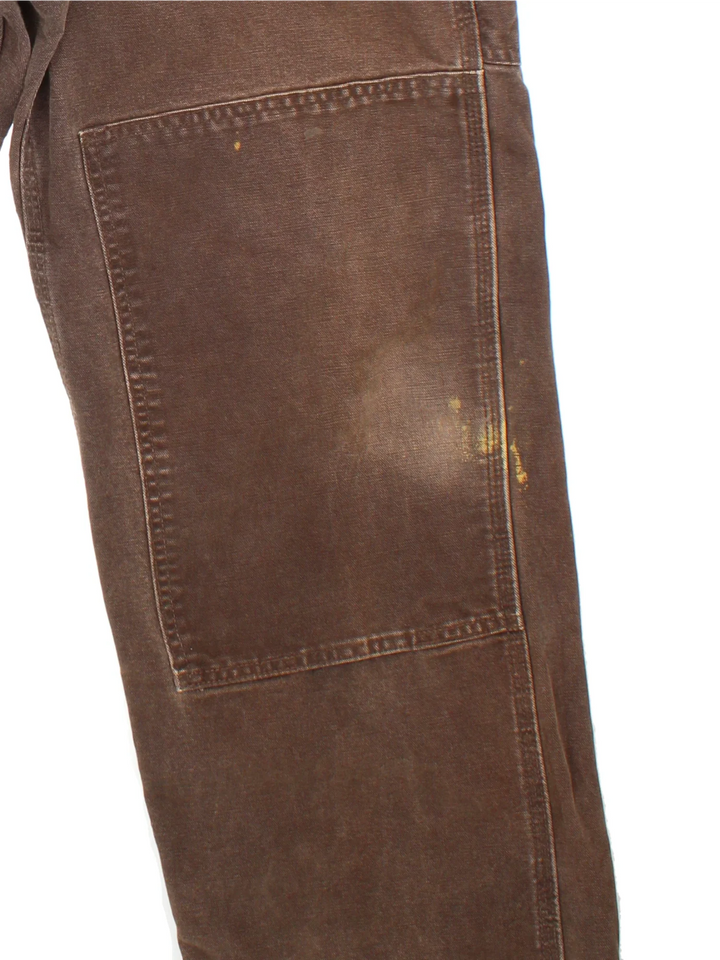 Carhartt Double Knee Dungarees in a brown colourway with multiple pockets and the logo embroidered on the front.