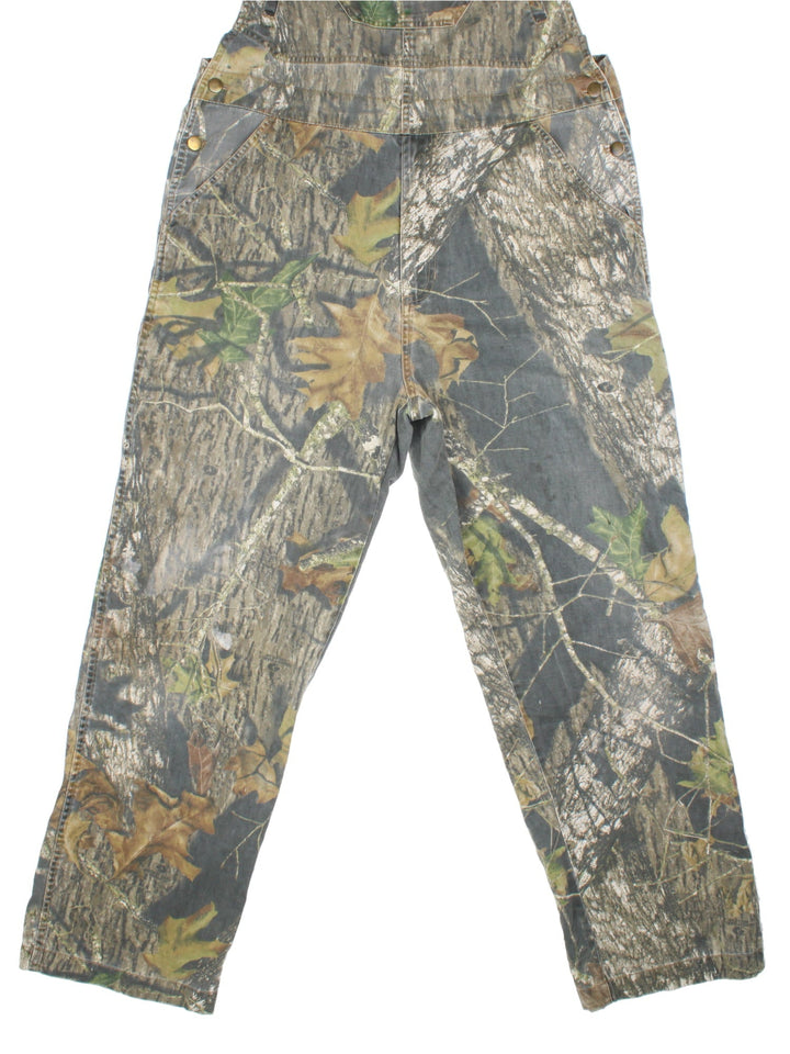 Vintage Forest Camo Dungarees in a green and brown colourway with multiple pockets, and adjustable straps.