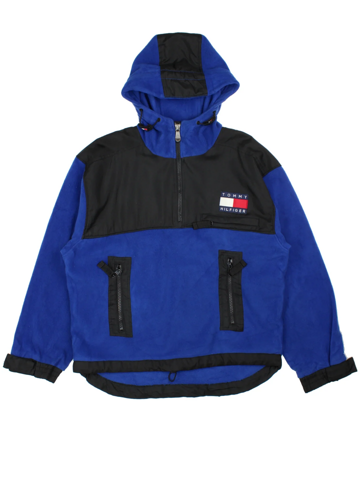Vintage Tommy Hilfiger Pullover Fleece in a blue colourway with black panelling. Half zip up closure and has multiple pockets, hooded, and the logo embroidered on the front.