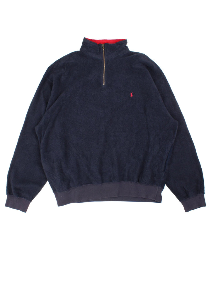 Ralph Lauren 1/4 Zip Fleece in a blue colourway. 1/4 zip up and has side pockets, and the logo embroidered on the front.