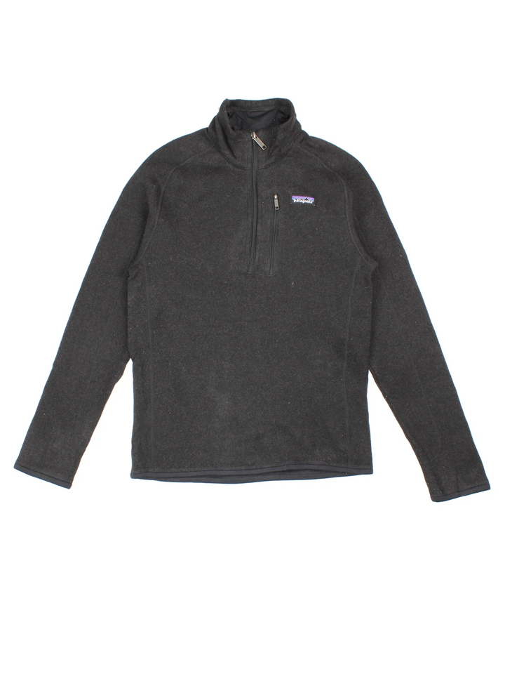 Patagonia Fleece in a black colourway. 1/4 zip up closure and has a chest pocket, and the logo embroidered on the front.