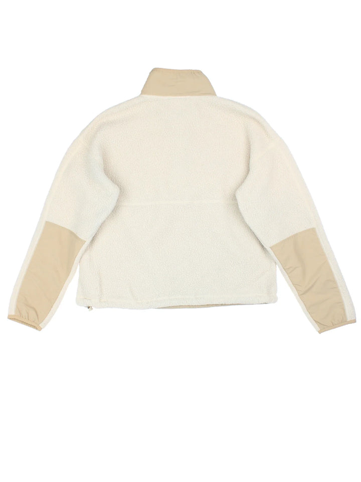 The North Face Cragmont Fleece in a tan colourway. 1/4 button up and has side pockets, and the logo embroidered on the front.