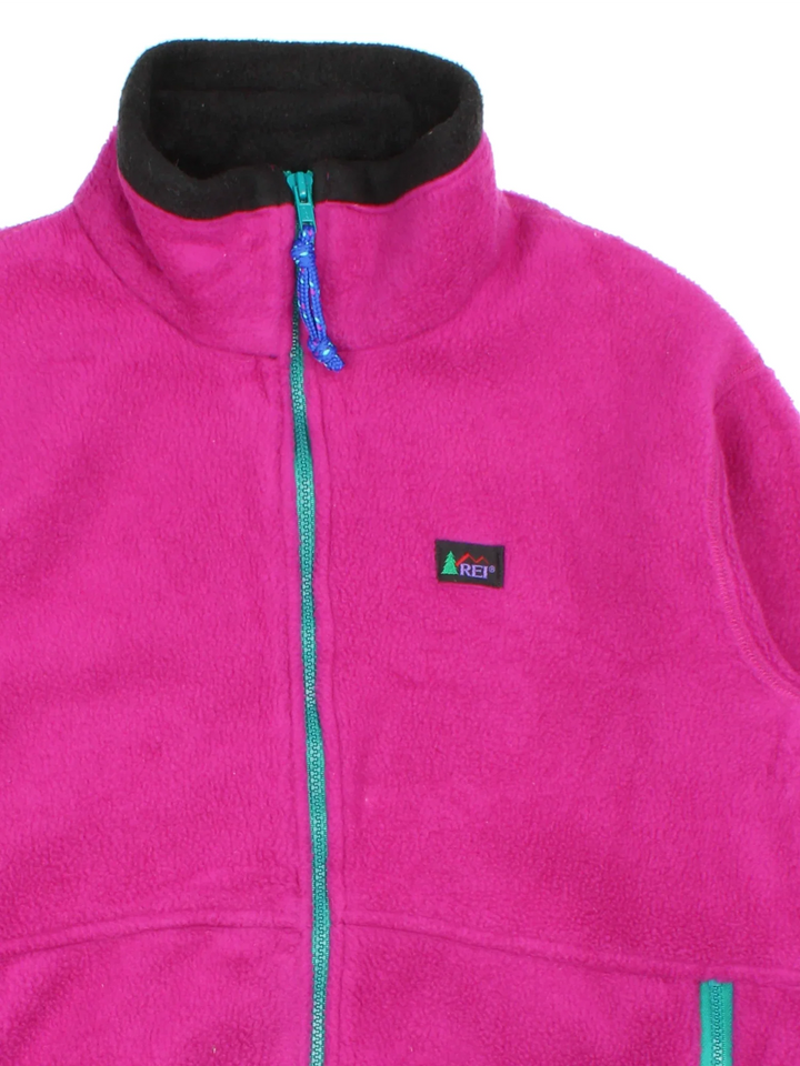 Vintage 90's REI Fleece in a pink colourway. Zips up and has side pockets, and the logo embroidered on the front.