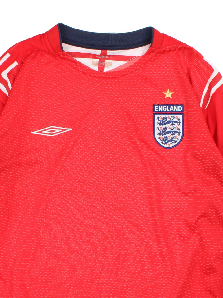 England 2004/06 Umbro Football Shirt in the red away kit colourway, features long sleeves, printed logos and badge on the front.