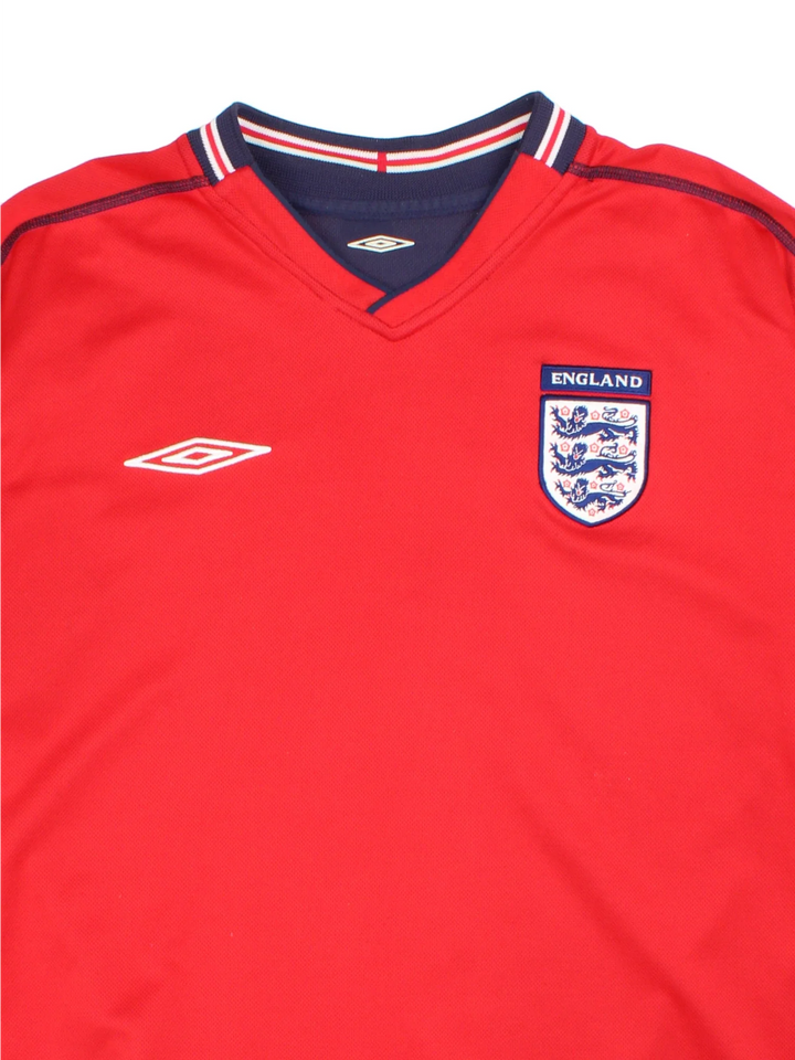 England 2002/04 Umbro Football Shirt in the red away kit colourway with reversible blue side, features printed logos and badge on the front.