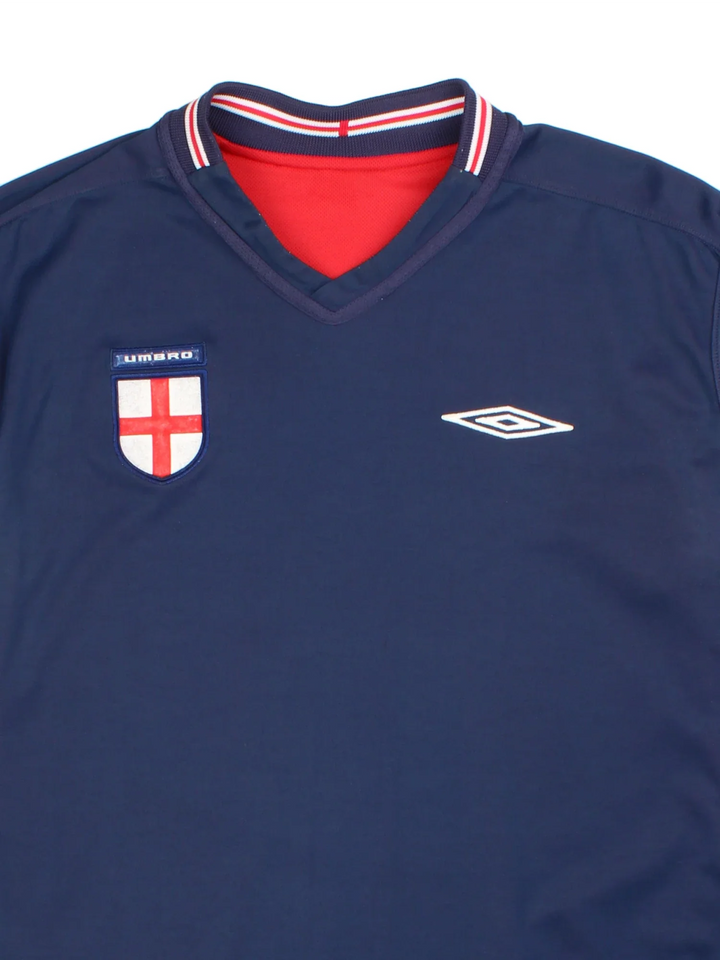 England 2002/04 Umbro Football Shirt in the red away kit colourway with reversible blue side, features printed logos and badge on the front.