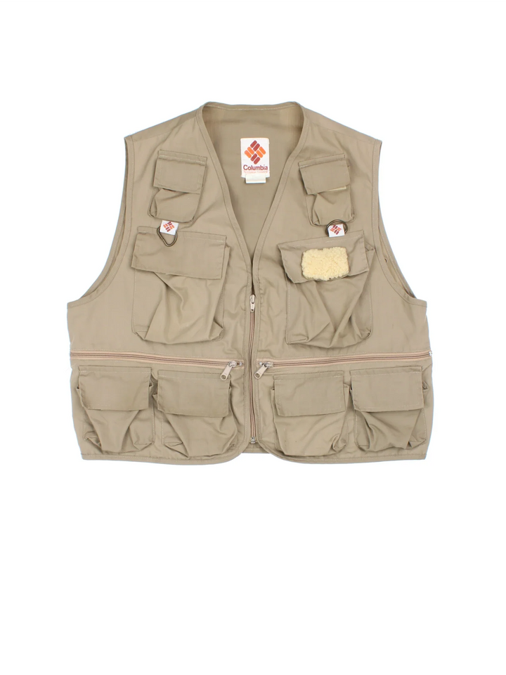 Vintage Columbia Fishing Vest in a tan colourway. Half zip up closure with multiple utility pockets, and has the logo embroidered on the front.