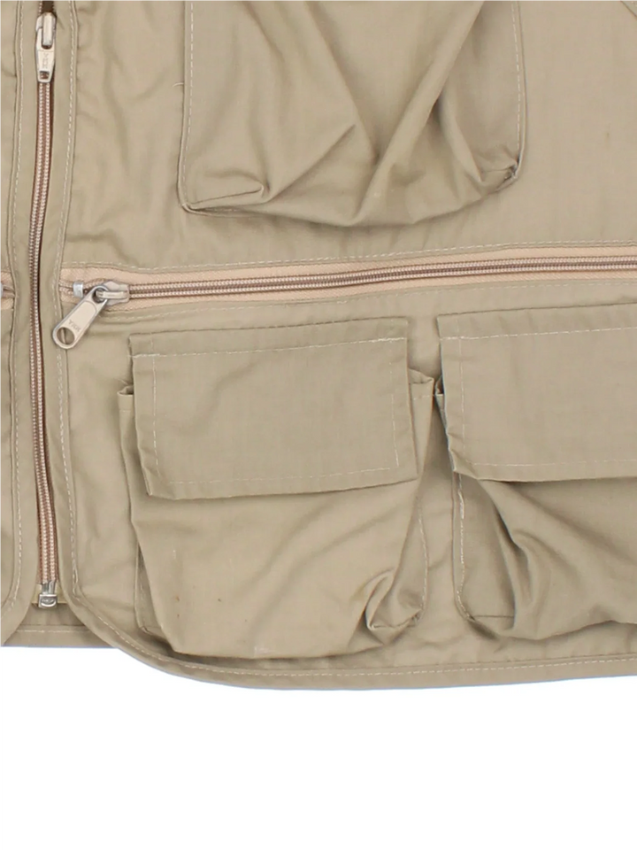 Vintage Columbia Fishing Vest in a tan colourway. Half zip up closure with multiple utility pockets, and has the logo embroidered on the front.