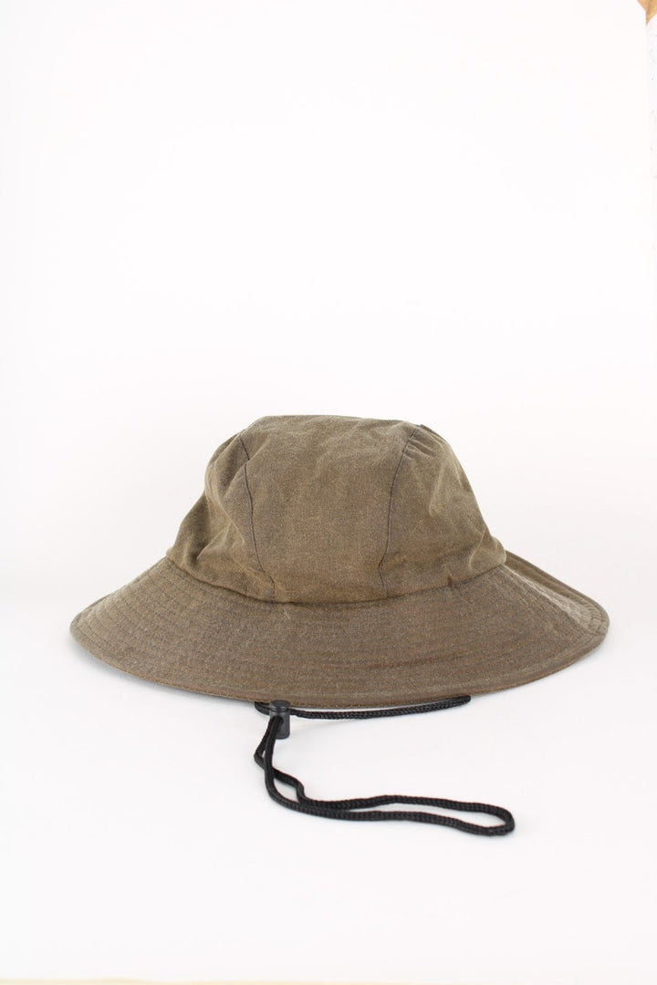 Barbour Wax Bucket Hat in a green colourway with tartan lining and ear flaps with drawstring..