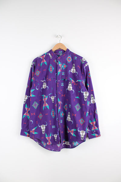 Vintage Wrangler Western button up shirt in purple, cow skulls and western patterns printed all over and has chest pockets. 