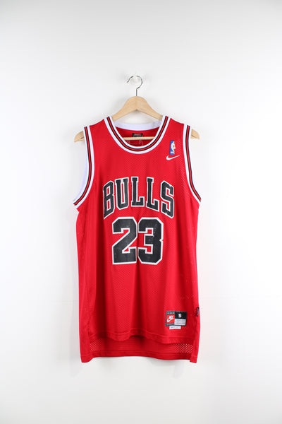 Chicago Bulls basketball jersey by Nike. Features embroidered Michael Jordan #23 lettering/ numbers on the front and back.  good condition- discoloration to the #23 on the front and back (see photos)  Size in Label:  S - Length +2  Our Measurements:   Chest: 21 inches Length: 29 inches