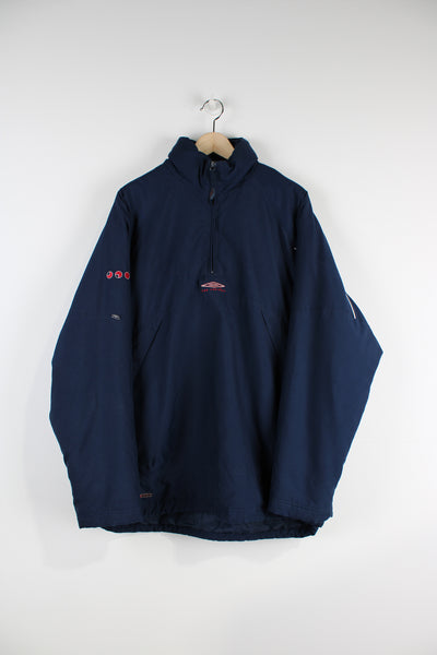 Blue 1/4 zip padded track top with embroidered Umbro logo on the chest and back. Features a fold away hood.  good condition  Size in Label:  L