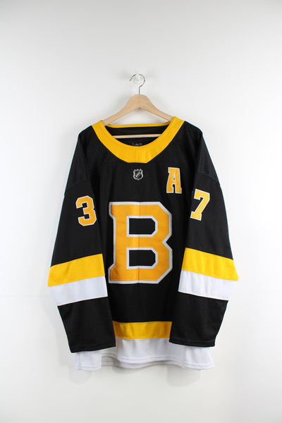 Boston Bruins NHL jersey with #37 Patrice Bergeron embroidered lettering and badges, Made by Adidas.  good condition- white section of the arms have some pulls and marks (see photos)  Size in Label:  USA 56 - Measures like a mens XXL  Our Measurements:  Chest: 28 inches Length: 30 inches