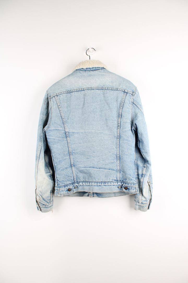 Vintage Levi's button up denim sherpa jacket in light blue with orange tab. Multiple pockets and white sherpa lining. 