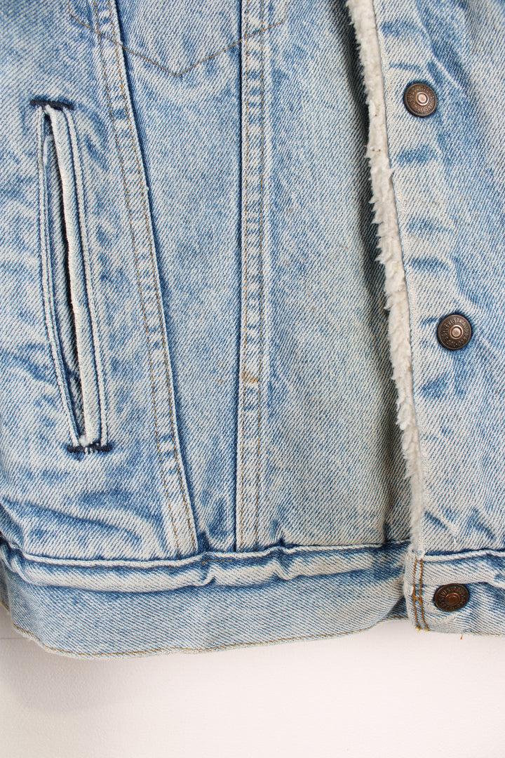Vintage Levi's button up denim sherpa jacket in light blue with orange tab. Multiple pockets and white sherpa lining. 