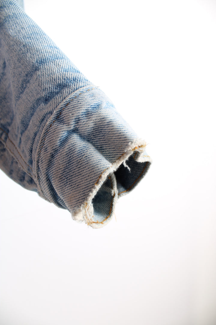 Vintage Levi's button up denim sherpa jacket in light blue with orange tab. Multiple pockets and white sherpa lining. 