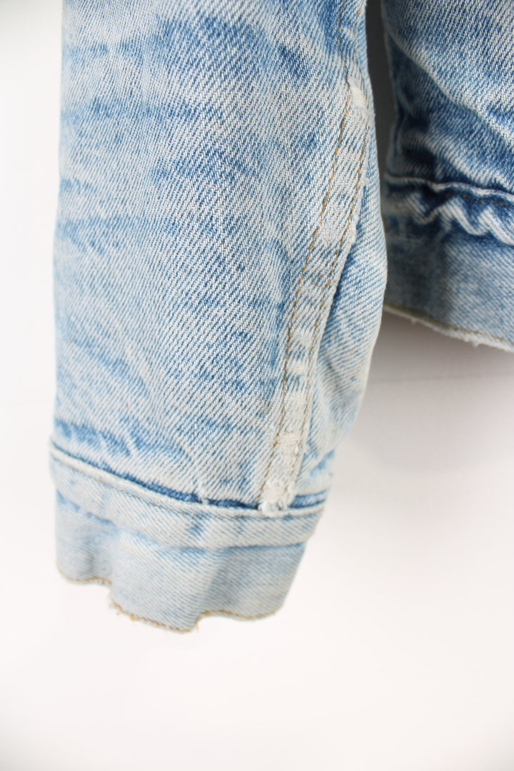 Vintage Levi's button up denim sherpa jacket in light blue with orange tab. Multiple pockets and white sherpa lining. 