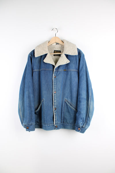 Vintage 80's Wrangler denim jacket in blue, button up jacket with a white sherpa lining, and camp collar.