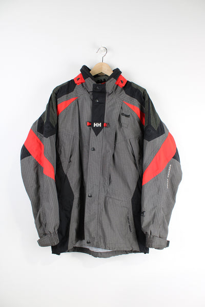 Vintage red and grey Helly Hansen, Helly Tech waterproof jacket, features multiple pockets and embroidered spell-out details on the chest and arm