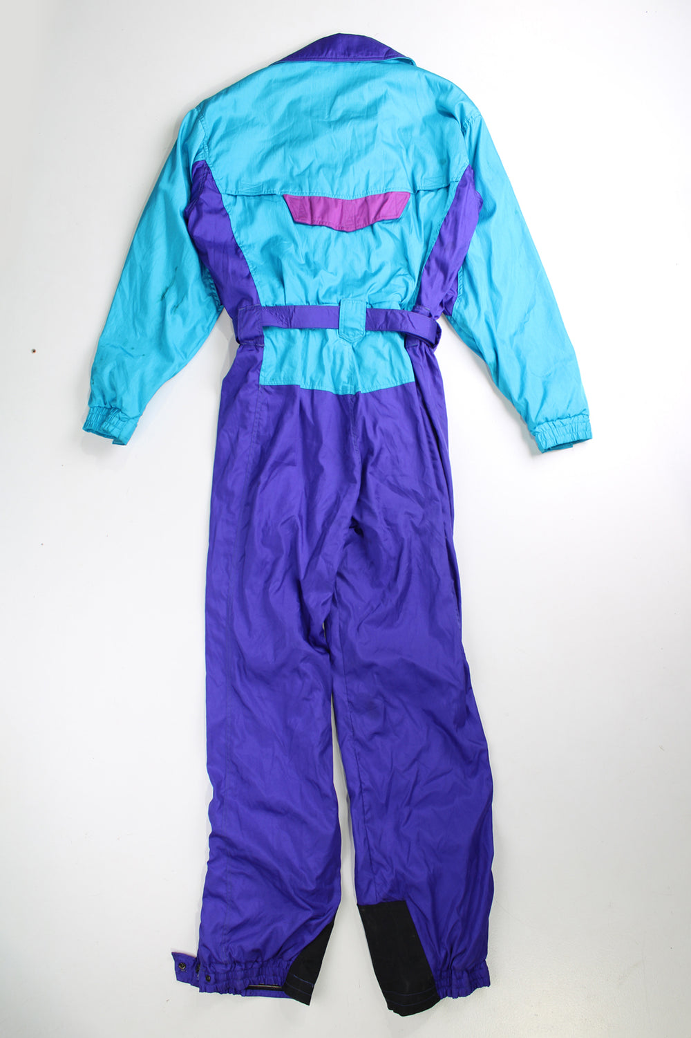Vintage 90's blue The North Face ski suit. Padded jumpsuit with belt. Closes with a zip/ velcro and has an elasticated waistband at the back. fair condition - Lots of marks throughout, has a old ski pass attached (see photos) Size in Label: Womens 10