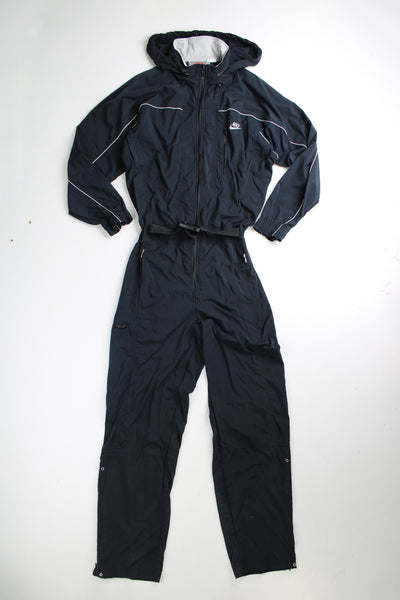 Vintage 90's Nike  black jumpsuit. Features embroidered logo on the chest, fold away hood and the waistband is elasticated at the back.  good condition - Four very small holes on the shoulder Size in Label: Mens M