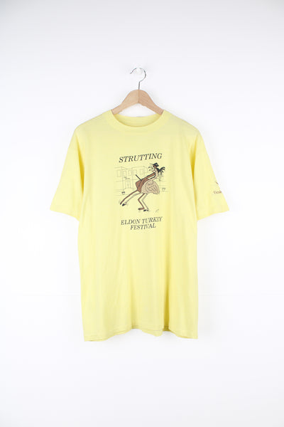 Vintage 1986 'Strutting' Eldon Turkey Festival in a pale yellow with printed graphic on the front, by Hanes