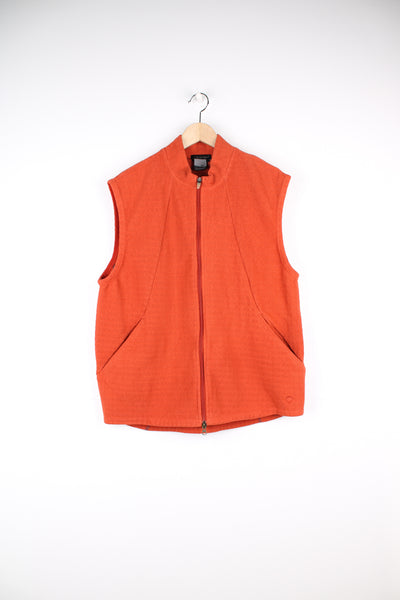 Nike Sphere Fleece Gilet in a orange colourway, zip up with side pockets, and has the logo embroidered on the front.