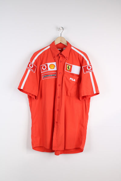 Vintage 2004 Ferrari x Fila team shirt in red, features embroidered sponsor badges all over. 