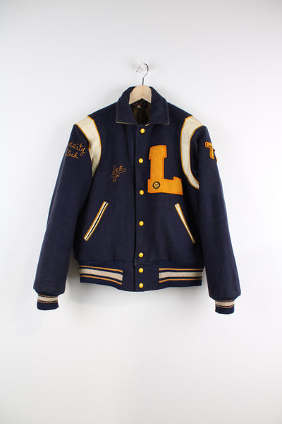 Vintage College Football Varsity Jacket in a blue, yellow and white colourway, woollen with a quilted lining, button up, and has embroidered name tag alongside logo badge on the chest