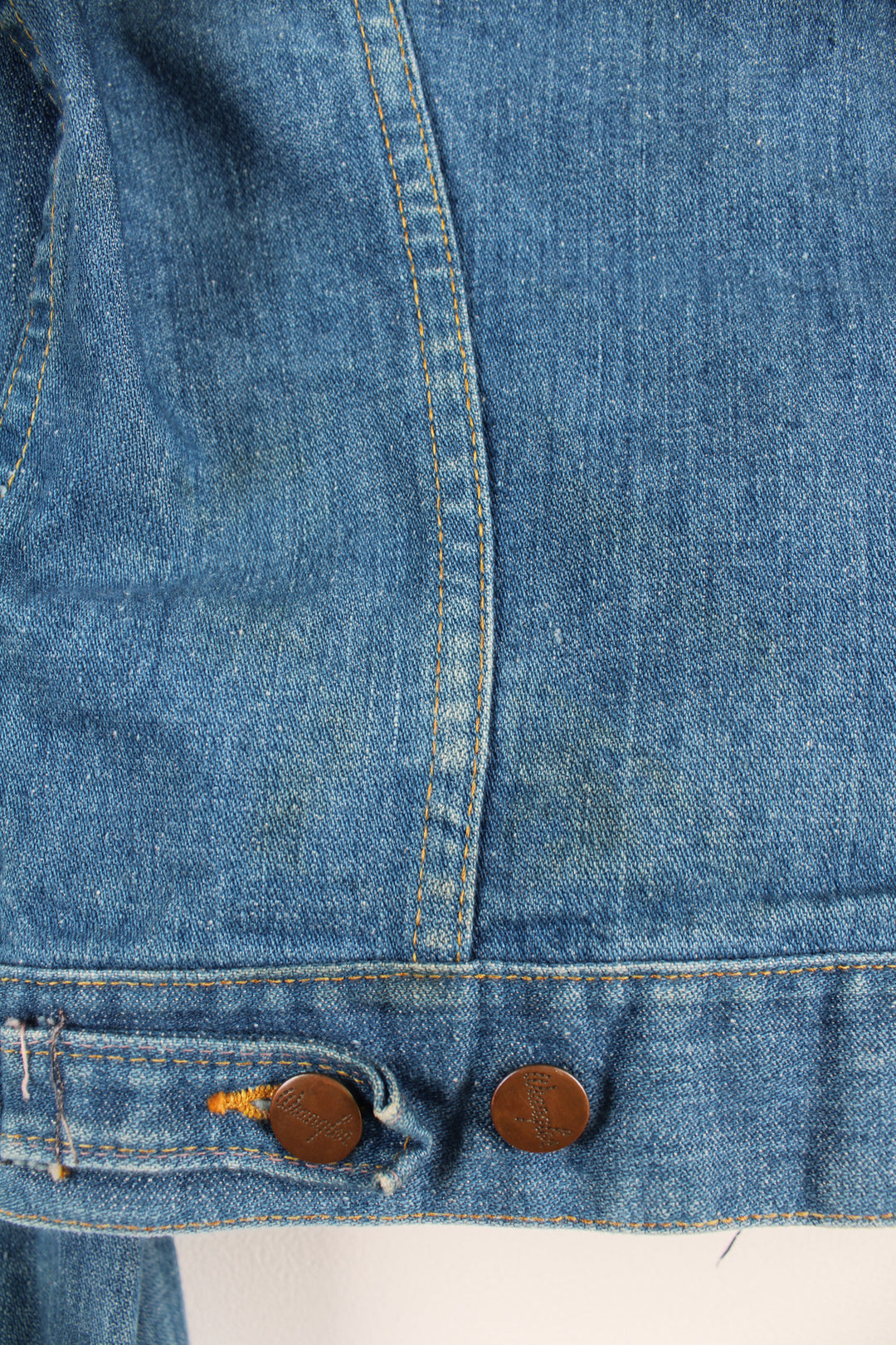 Vintage Wrangler Denim Jacket in a blue colourway with brown cross stitching throughout, button up, multiple pockets, and has logo embroidered on the chest.