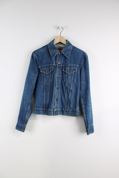 Vintage Levi's Denim Jacket in a blue colourway, button up, double chest pockets, and has orange tab logo embroidered on the chest.