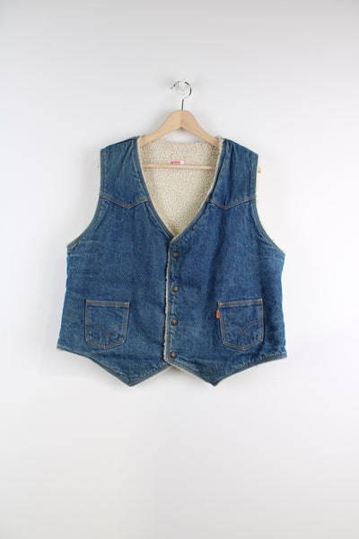 Vintage Levi's Denim Vest in a blue colourway with a white sherpa lining, button up, side pockets, and orange tab logo embroidered on the front.