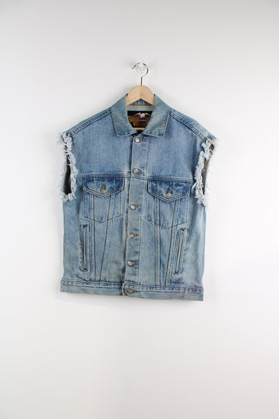 Vintage Harley Davidson Denim Vest in a blue colourway, button up, multiple pockets, distressed style and has big American flag print on the back with logo spell out going across.