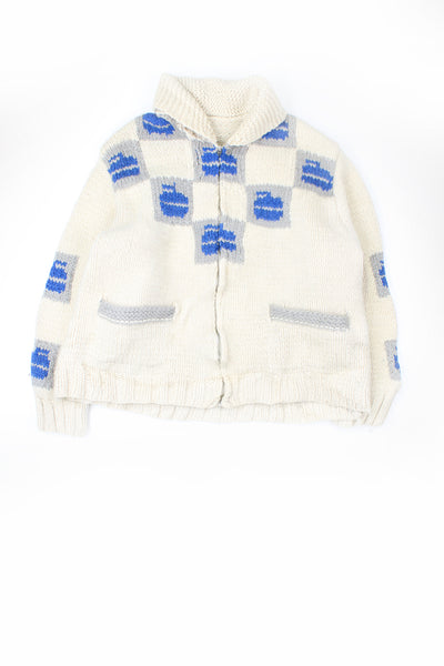 Vintage chunky knit cardigan in cream with blue curling design. No label - presumably handmade. Has two front pockets and closes with a zip.    good condition - some bobbling in places  Size in Label:  No Size - Measures like a size L