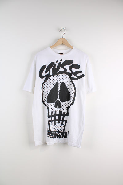 Stussy Worldwide T-Shirt in a white and black colourway, and has a big skull graphic printed alongside the logo.