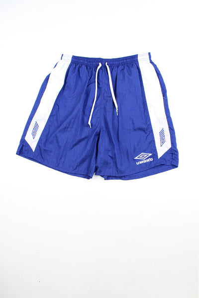 Blue Umbro sports shorts with elasticated waist and drawstring. Features embroidered logo and white stripe detail down each leg.