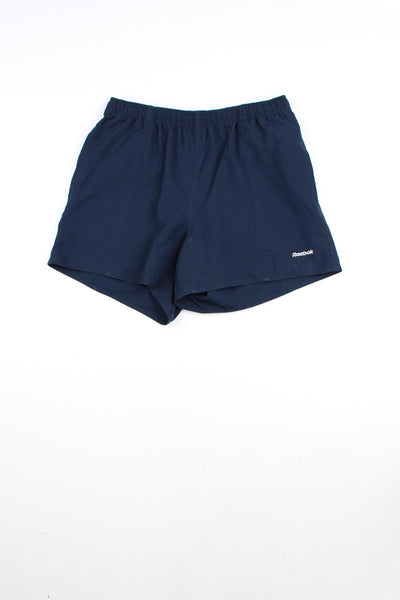 Navy blue Reebok shorts with elasticated waist and drawstring. Features embroidered logo on the leg.