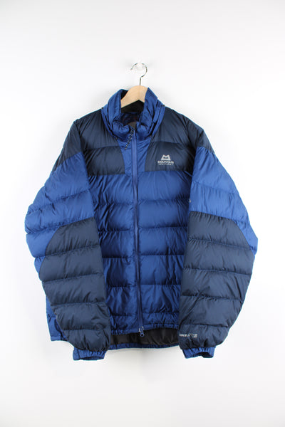Navy blue Mountain Equipment puffer jacket with drawstring hem and zip up pockets