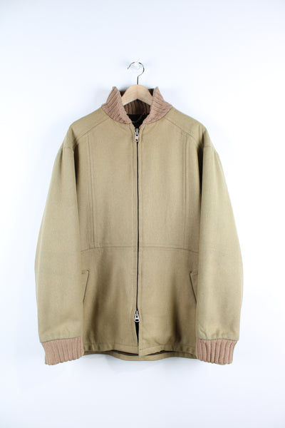 Vintage Woolrich wool jacket in a tan colour, has a brown corduroy collar, zip up with side pockets, and brown fleece lining.