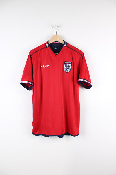 2002/04 England Away Kit, has embroidered logos on the front, and is a reversible shirt which can change the colourway from red to blue.